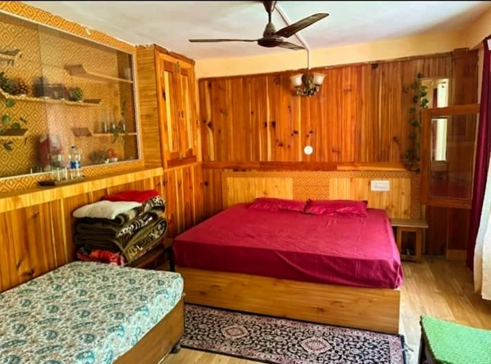 Deluxe room at Tirthan Midpoint Homestay with wooden interiors